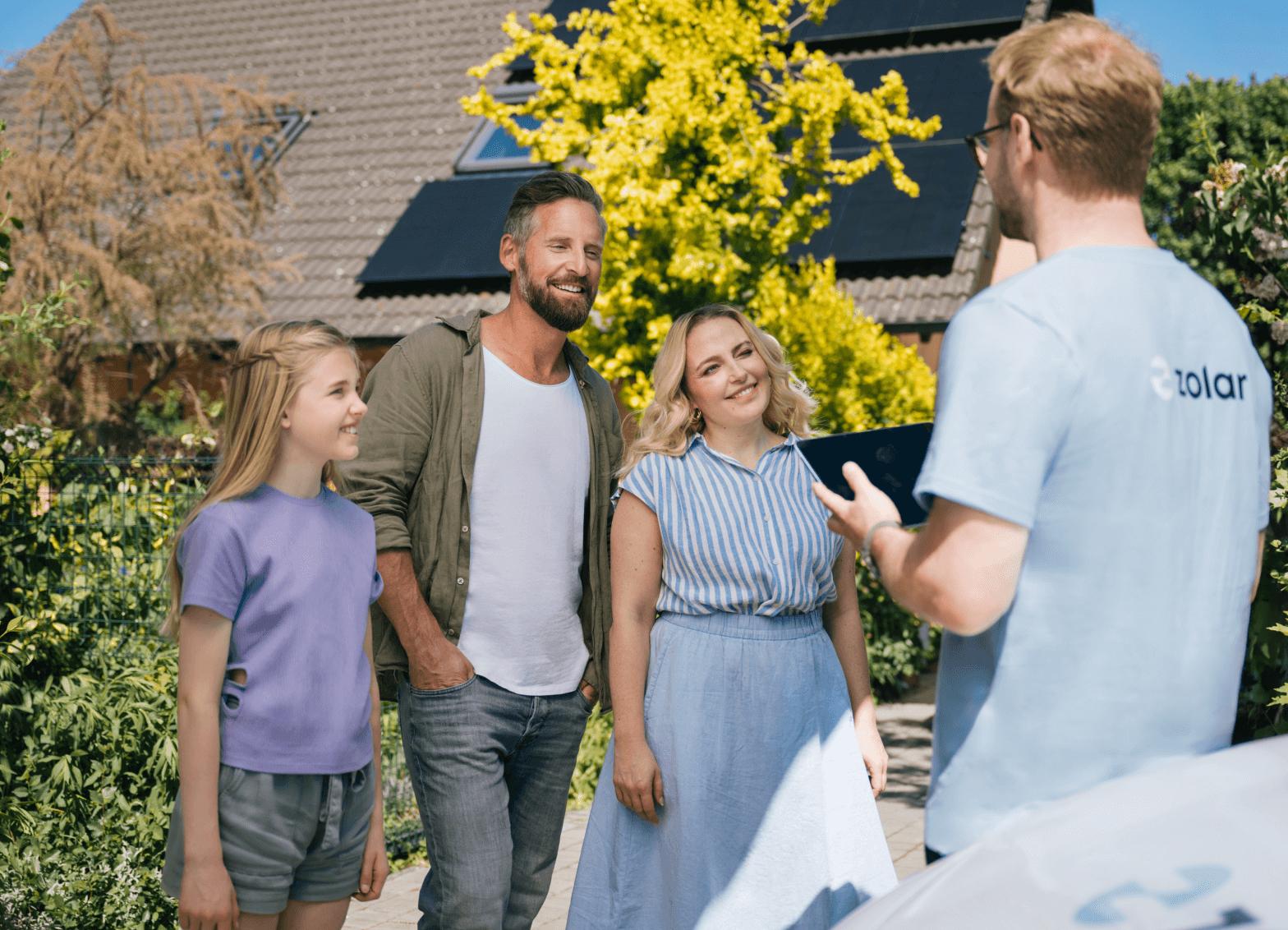 Glückliche Familie for dem Haus mit zolar Mitarbeiter im Gespräch